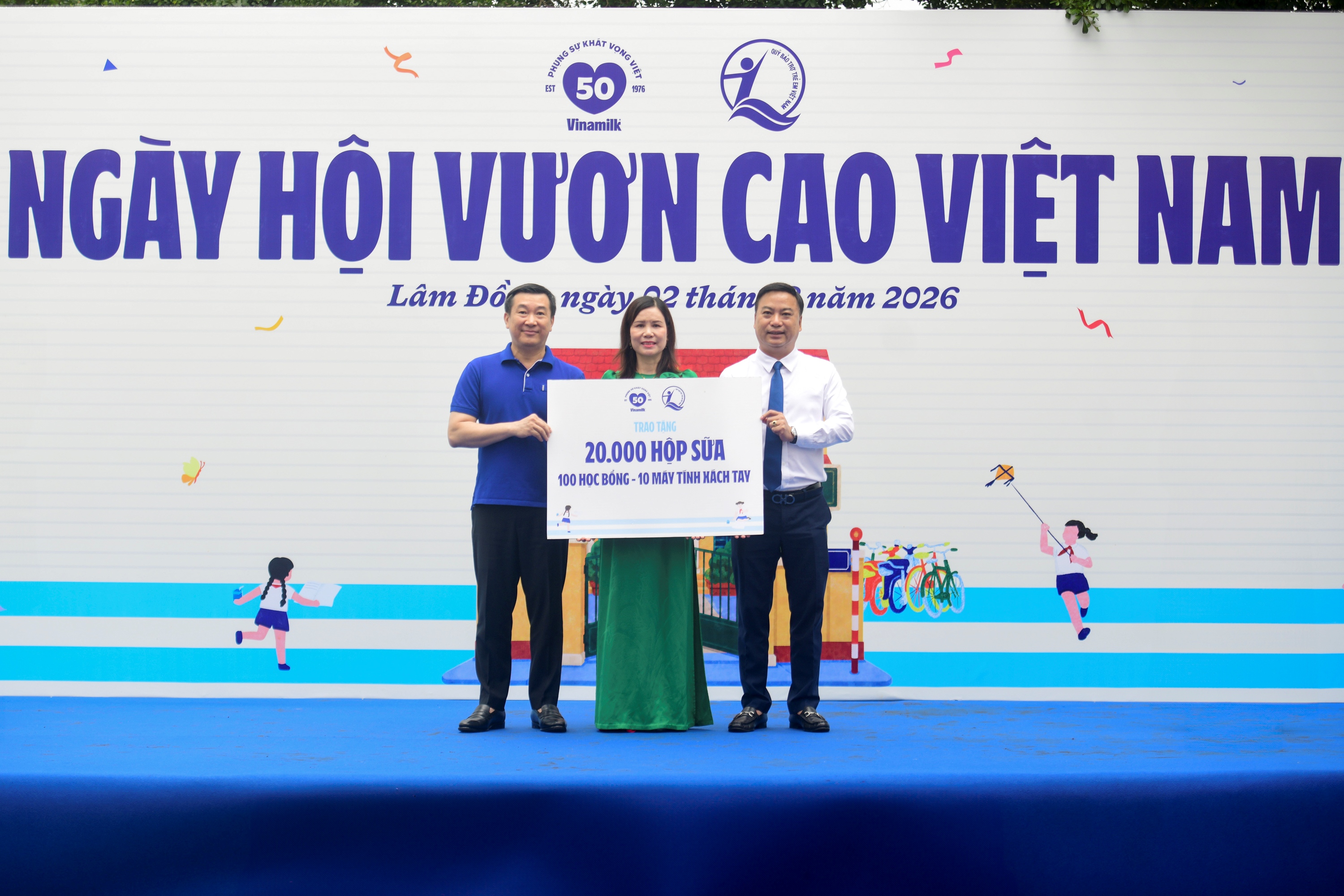 Đại diện Quỹ sữa Vươn cao Việt Nam, &ocirc;ng Đỗ Thanh Tuấn - Gi&aacute;m đốc Đối ngoại Vinamilk (b&ecirc;n tr&aacute;i) v&agrave; &ocirc;ng Đinh Tiến Hải - Gi&aacute;m đốc Quỹ Bảo trợ Trẻ em Việt Nam - trao bảng tượng trưng c&aacute;c phần qu&agrave; thiết thực cho đại diện Trường Tiểu học An Hiệp, x&atilde; Hiệp Thạnh.
