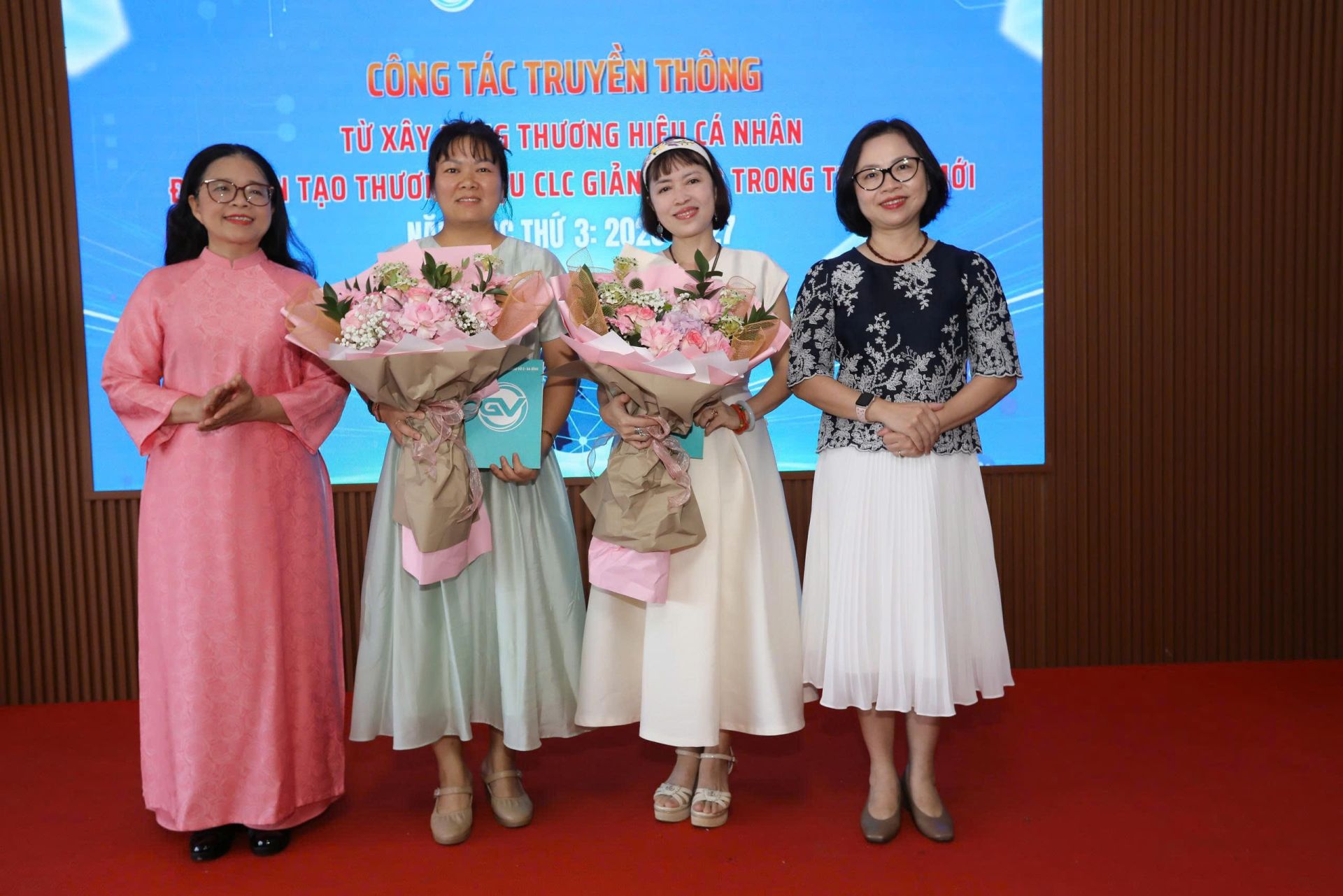 Nh&agrave; gi&aacute;o Nguyễn Hương Giang &aacute;o &ndash; Hiệu trưởng - nữ tướng &aacute;o hồng tặng hoa cho hai diễn giả.