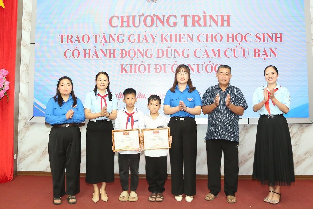 Đại diện Đo&agrave;n x&atilde; Thuận Ch&acirc;u trao tặng Giấy khen của Hội đồng Đội tỉnh Sơn La cho T&ograve;ng Văn Khắc Huy (thứ ba từ tr&aacute;i qua) v&agrave; Lường Hải Nam.