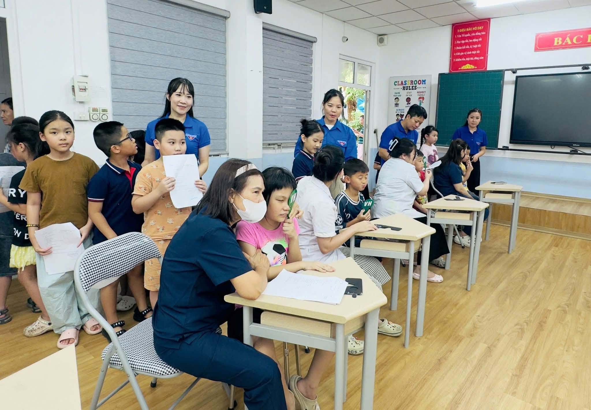 Đo&agrave;n vi&ecirc;n, thanh ni&ecirc;n hỗ trợ hướng dẫn v&agrave; sắp xếp học sinh tại khu vực kh&aacute;m sức khỏe. (Ảnh: Đo&agrave;n phường Hai B&agrave; Trưng)