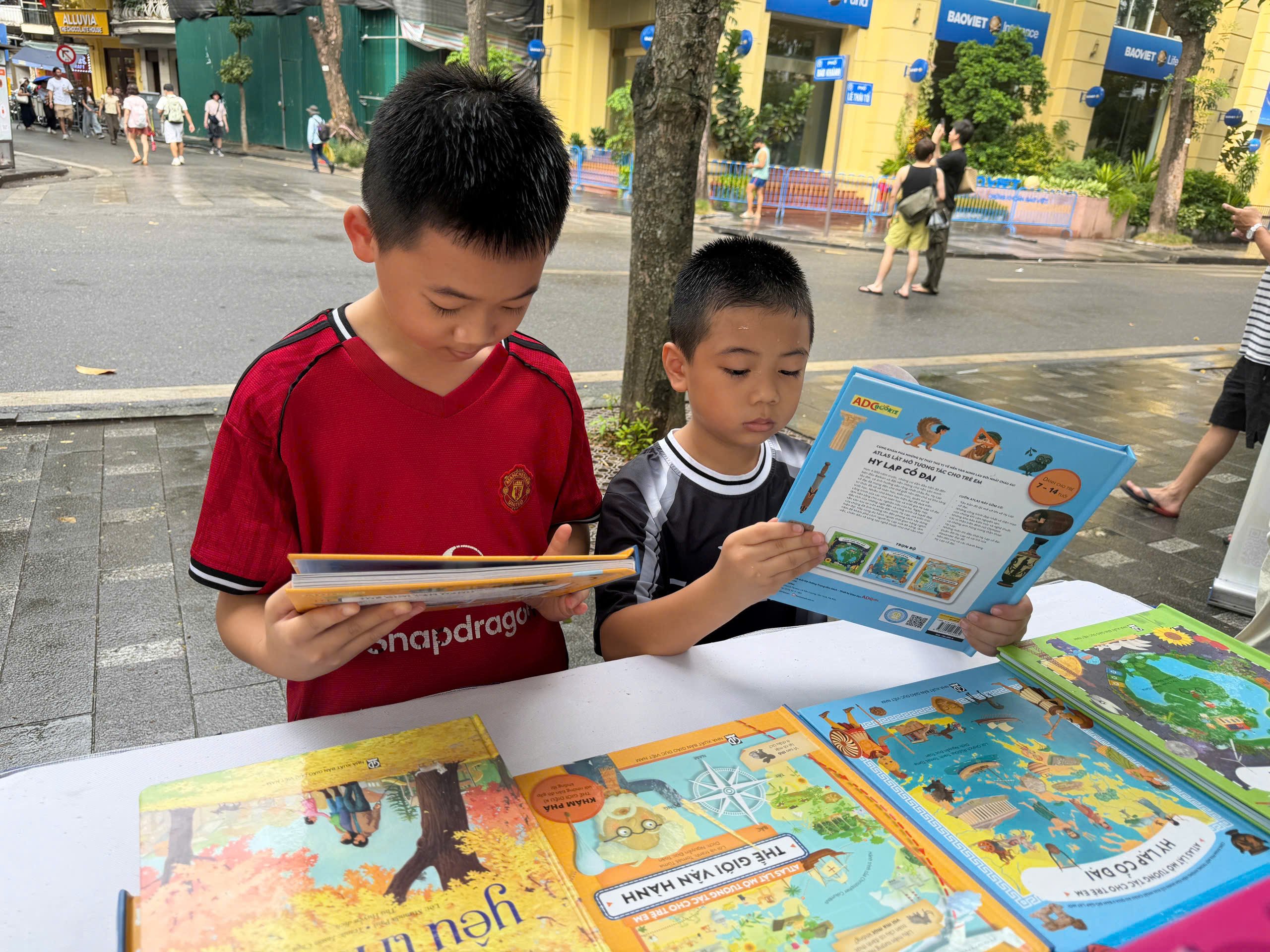 Hai anh em Vũ Đức Thắng v&agrave; Vũ Đức Tuấn (trường Tiểu học Nguyễn Qu&yacute; Đức, phường T&acirc;y Mỗ, H&agrave; Nội) h&agrave;o hứng chọn s&aacute;ch.