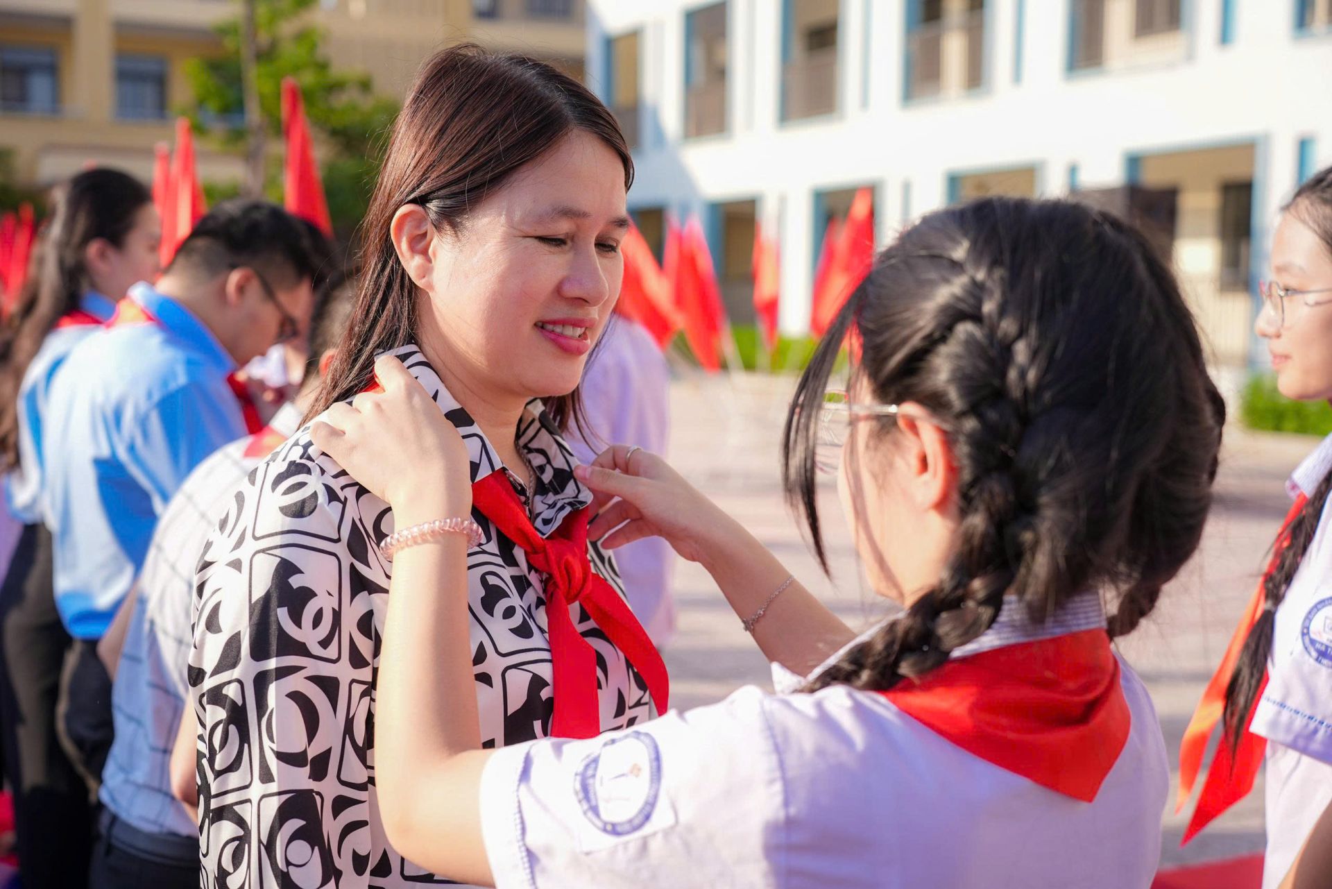 Đội vi&ecirc;n đeo khăn qu&agrave;ng đỏ cho c&ocirc; Nguyễn Thị Thương - Hiệu trưởng nh&agrave; trường