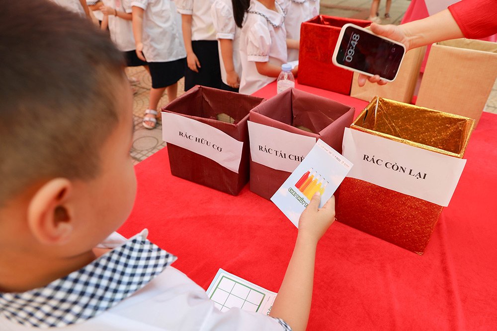 Học sinh thực h&agrave;nh ph&acirc;n loại r&aacute;c tại trạm tr&ograve; chơi &ldquo;Chiến thần ph&acirc;n loại&rdquo;.