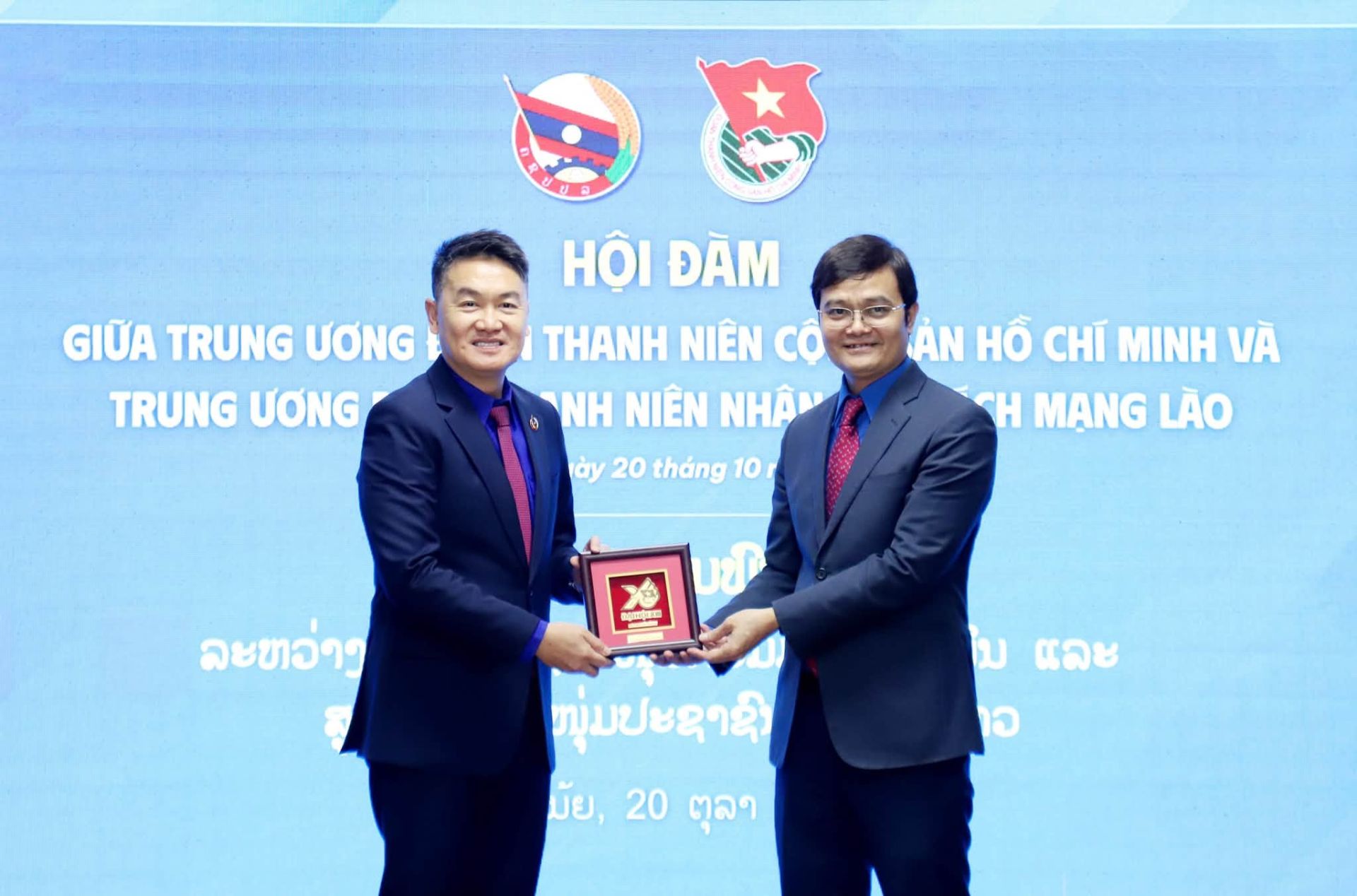 Anh B&ugrave;i Quang Huy - B&iacute; thư thứ nhất Trung ương Đo&agrave;n TNCS Hồ Ch&iacute; Minh (b&ecirc;n phải) v&agrave; anh Thongly Sisoulith - B&iacute; thư Trung ương Đo&agrave;n Thanh ni&ecirc;n Nh&acirc;n d&acirc;n C&aacute;ch mạng L&agrave;o trao qu&agrave; lưu niệm tại hội đ&agrave;m. Ảnh: Đo&agrave;n Thanh ni&ecirc;n.