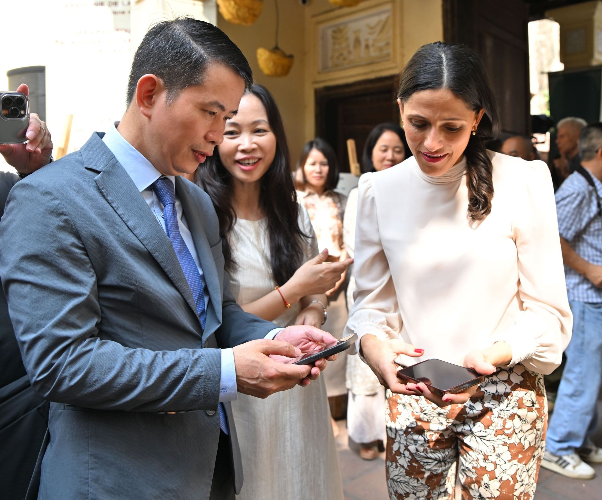 &Ocirc;ng Phạm Tuấn Long v&agrave; b&agrave; &Eacute;l&eacute;onore Caroit trải nghiệm nền tảng số &ldquo;H&agrave;nh tr&igrave;nh du lịch di sản H&agrave; Nội&rdquo; tr&ecirc;n điện thoại.